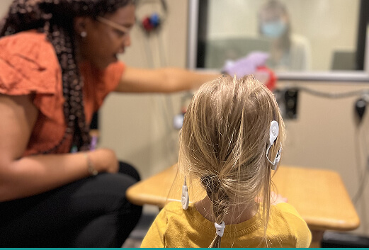 Hearing specialist with a girl wearing a cochlear implant