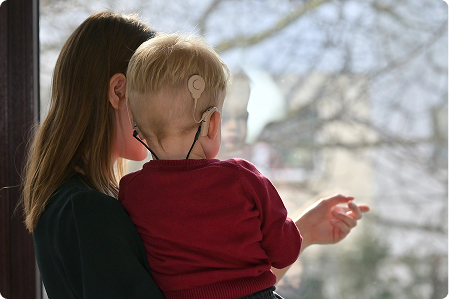 Mother with child wearing a cochlear implant